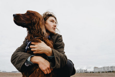 Portrait of a young woman with her dog. Irish setter dog in the arms of the loving mistress.の写真素材