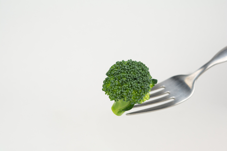 Broccoli on a fork isolated on white backgroundの写真素材