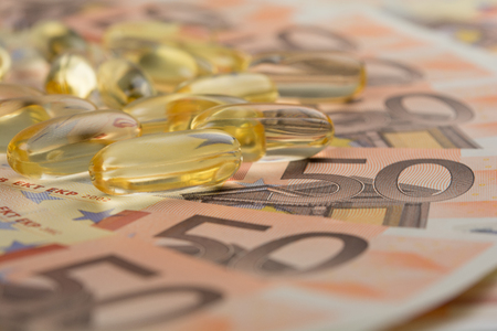 Gel capsules and money in drug expense concept.の写真素材