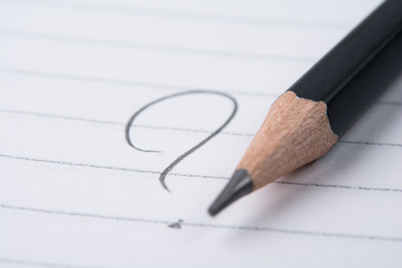Handwritten question mark on a notepad. Shallow dofの写真素材