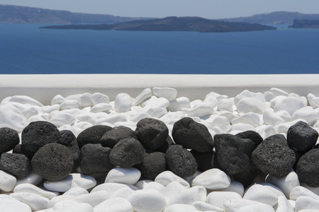 Black volcanic stones over white. Decoration detail at Santorini, Greece.の写真素材