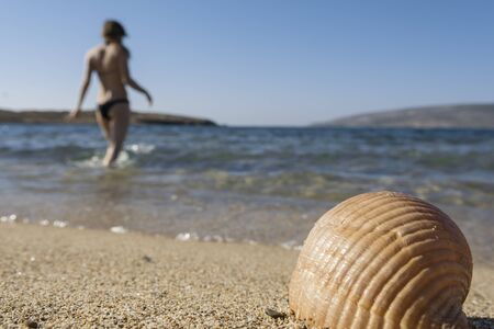 unrecognizable young woman enters the sea in a recreation concept. selective focusの写真素材