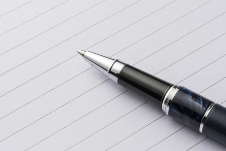 metal pen on a sheet of paperの写真素材