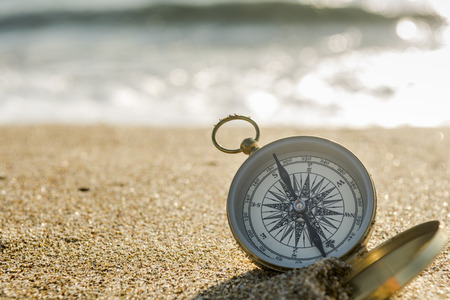 compass on the golden sand by the seaの写真素材