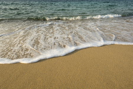 Close up of foamy soft wave on sand beachの写真素材
