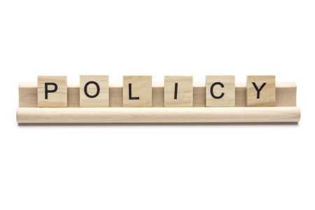 Word ''policy'' on  wooden letters on a rack, isolated on white backgroundの写真素材
