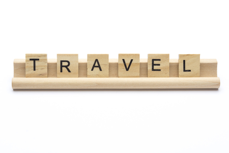 Word ''travel'' on  wooden letters on a rack, isolated on white background.の写真素材