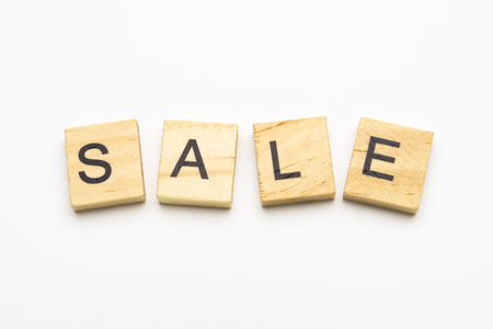 Sale word on wooden puzzle tiles isolated on white backgroundの写真素材