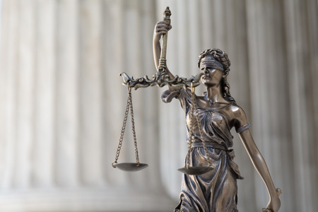 The statue of justice Themis or Iustitia, the blindfolded goddess of justice against an ionic order colonnade, as a legal conceptの写真素材