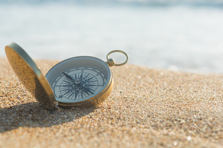 compass on the golden sand by the seaの写真素材