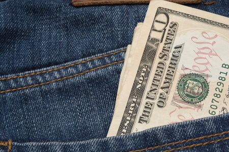 US dollars in the back pocket of a blue jeans