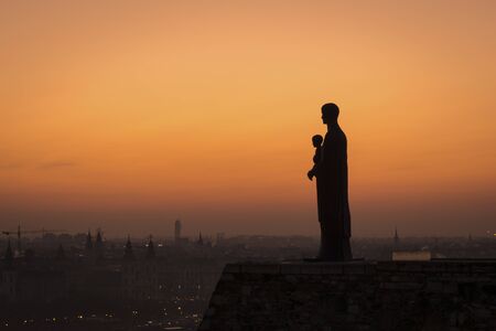 Silhouette of the statue of virgin mary at sunrise at Buda castle, Budapest, Hungaryの写真素材
