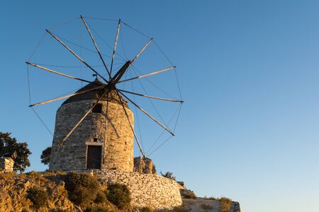 Traditional old stone windmill, iconic building located on all Greek islandsの写真素材