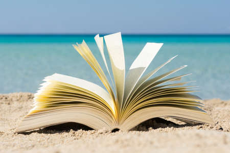 Open book on the sand at the beach, close upの写真素材
