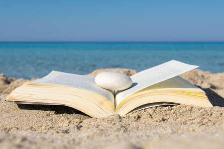 Open book on the sand at the beach, close upの写真素材