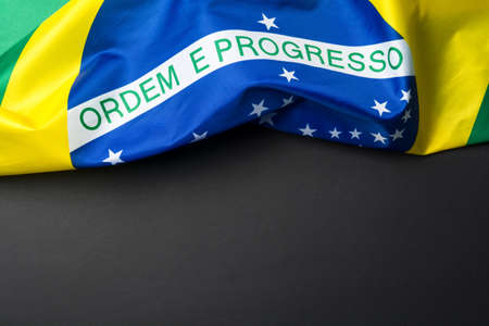 Brazilian flag lying on black grainy backgroundの写真素材