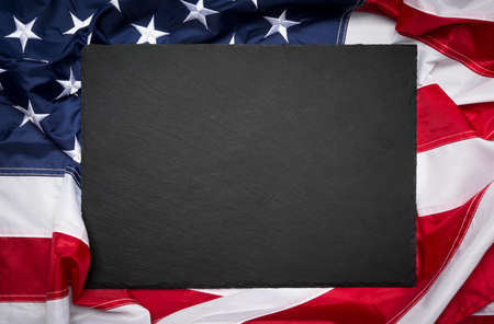 Blank slate board over American flag as a concept for US national celebrationsの写真素材