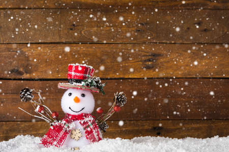 Happy snowman against wooden background with copy-space, as a concept for Merry Christmas and happy new year greeting cardの写真素材