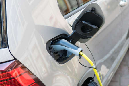Close up of the power supply plugged into an electric car. Eco car concept