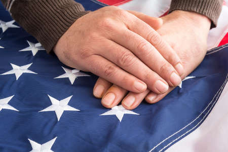 Male hands touch the flag of the United States of Americaの写真素材