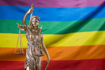The blindfolded goddess of justice Themis or Justitia against the rainbow flag of LGBT community, as a LGBT social issues conceptの写真素材