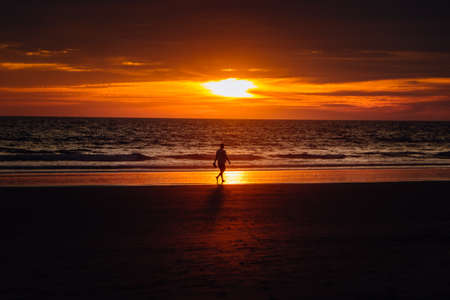 man walking alone on a beach in huelvaの写真素材