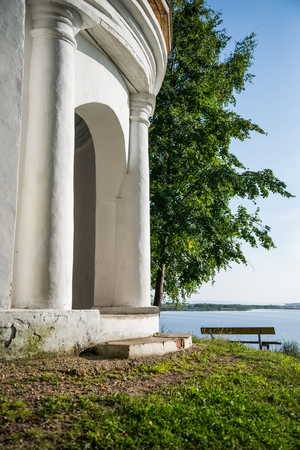 White stone arch at the picturesque riverbank. Near spreading treeの写真素材