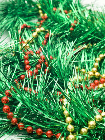 Christmas comes - green tinsel and beads over whiteの写真素材