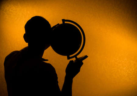 Listen to the world - silhouette of man in the darknessの写真素材