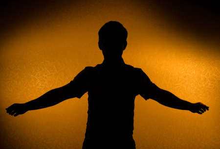 Breakthrough - male silhouette with opened arms (back light)の写真素材