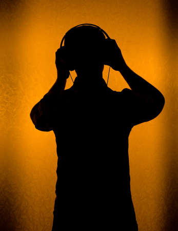 Music - silhouette of DJ with headset (back light)の写真素材