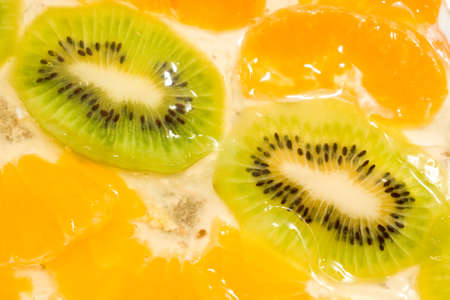 Fruit background. Sliced kiwi and mandarin segmentsの写真素材