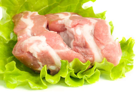 Pieces of Pork meat on green salad. Isolated over whiteの写真素材