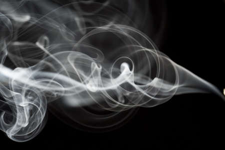 Abstract black smoke swirls over the black backgroundの写真素材
