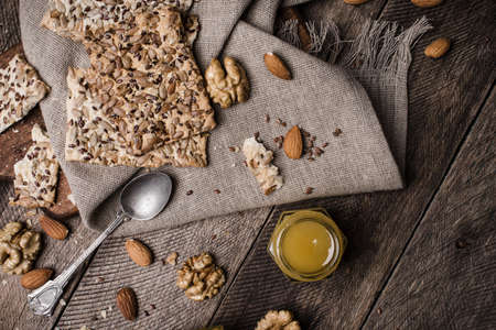 Nuts, Cookies with seeds and honey on wooden table. Rustic style and autumn food photoの写真素材