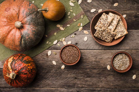 Rustic style autumn pumpkins with cookies and seeds on wood. Autumn Season food photoの写真素材