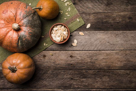 Rustic style pumpkins with seeds on wooden table. Autumn Season food photoの写真素材