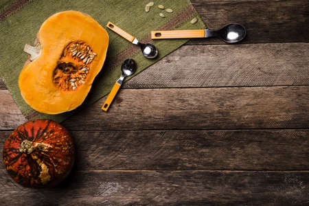 Rustic style pumpkins with seeds on green napkin and wood. Autumn Season food photoの写真素材