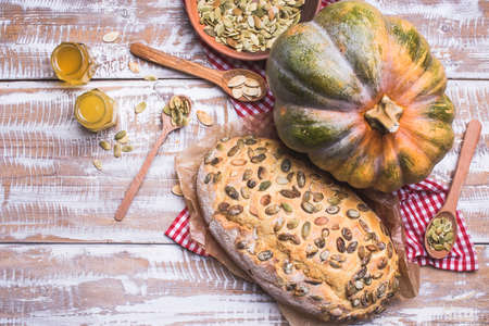 Newly baked bread with seeds and pumpkin on wooden table. Rustic style food photo