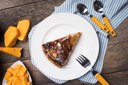 Breakfast pie on plate and pieces of pumpkin on wood in Rustic style. Food Photoの写真素材