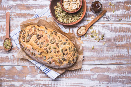 Newly fledged bread with pumpkin seeds on wooden table. Rustic styleの写真素材