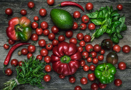 vegetables on wooden table in rustic style. Tomatoes, pepper, avocado, basilの写真素材