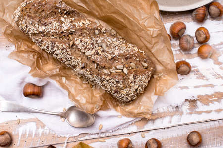 Bread with seeds huzelnuts on wooden board in rustic styleの写真素材