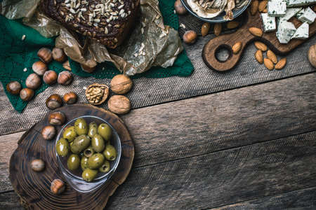nuts mushrooms bread and olives on wooden table  in rustic styleの写真素材
