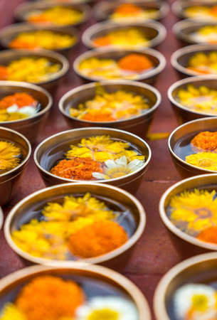 Buddhist flower offerings or gifts in bowls and rows. Buddhism religion offering in a temple