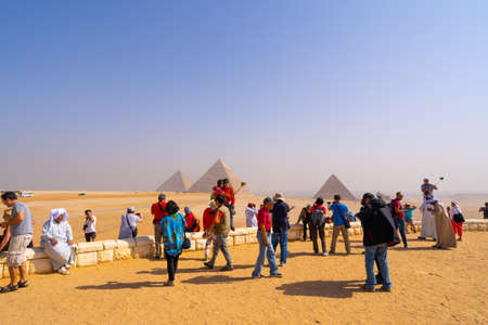 People taking photos and selfies near Pyramids of Giza in Cairo. Captured in Egypt. Autumn 2018