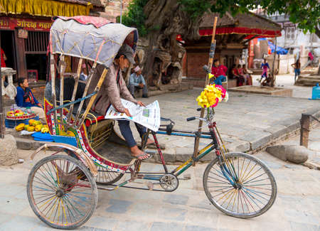 rickshaw driver reading newspaper in Kathmandu. Captured in Nepal, spring 2018のeditorial素材
