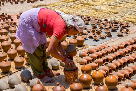 Woman glazing ceramic pots on Bhaktapur square. Captured in Nepal, Kathmandu valley in spring 2017のeditorial素材