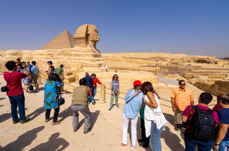 Tourists and Great Sphinx of Giza, with the Great Pyramid in the background. People take selfies. Cairo, autumn 2018のeditorial素材