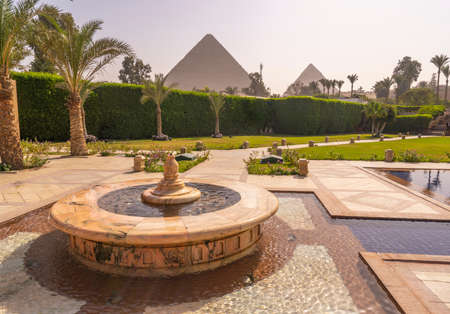 Fountain and swimming pool with Cheops pyramid in the background. Pyramids of Giza near Cairo, Egypt. Autumn 2018のeditorial素材